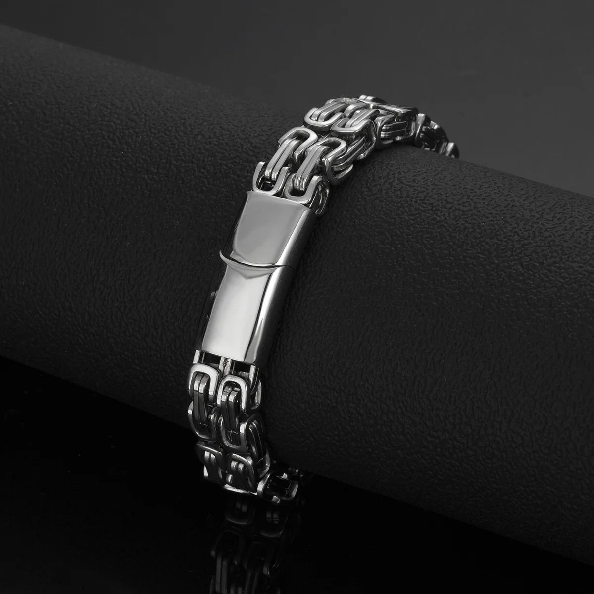 Silberfarbenes Herren-Gliederarmband mit Verschluss auf schwarzem Hintergrund