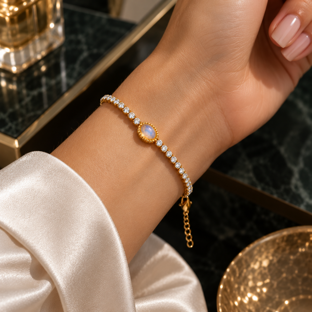 Goldfarbenes Armband mit rundem, hell schimmerndem Schmuckelement zu einer weißen Bluse