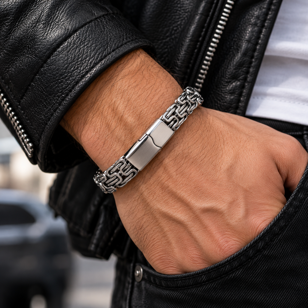 Silberfarbenes Herren-Gliederarmband am Handgelenk zu einer dunklen Jacke