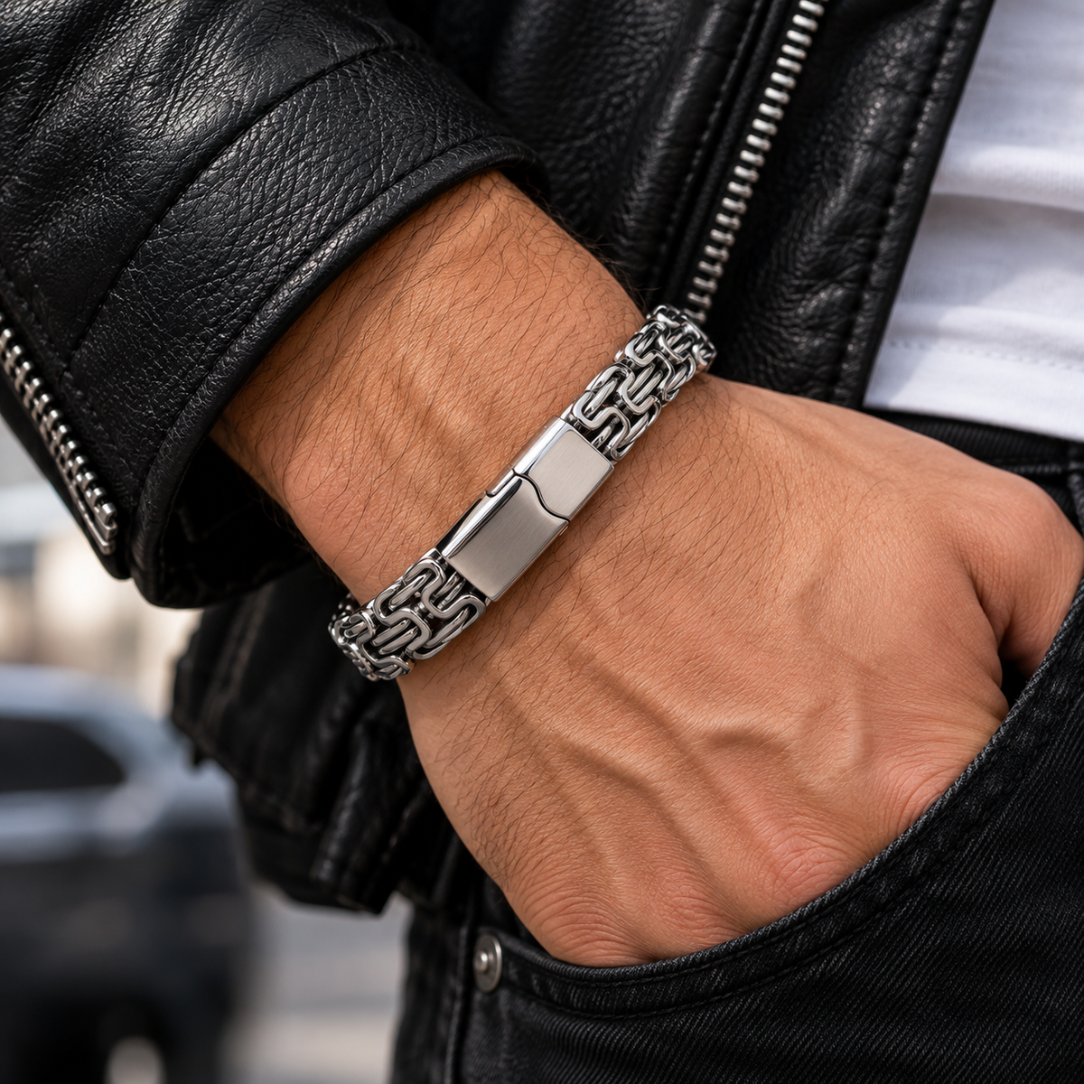 Silberfarbenes Herren-Gliederarmband am Handgelenk zu einer dunklen Jacke