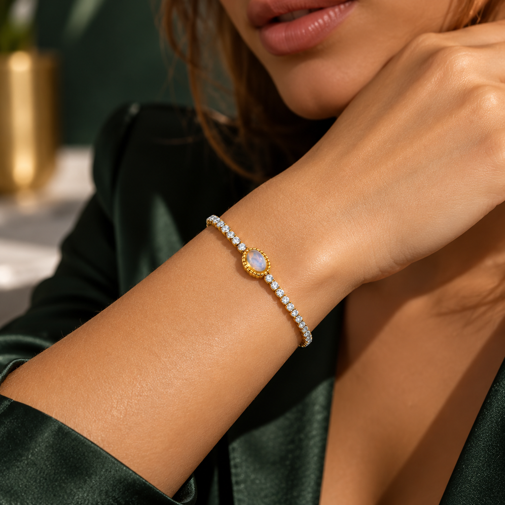 Goldfarbenes Armband mit rundem, hell schimmerndem Schmuckelement zu einem dunkelgrünen Oberteil