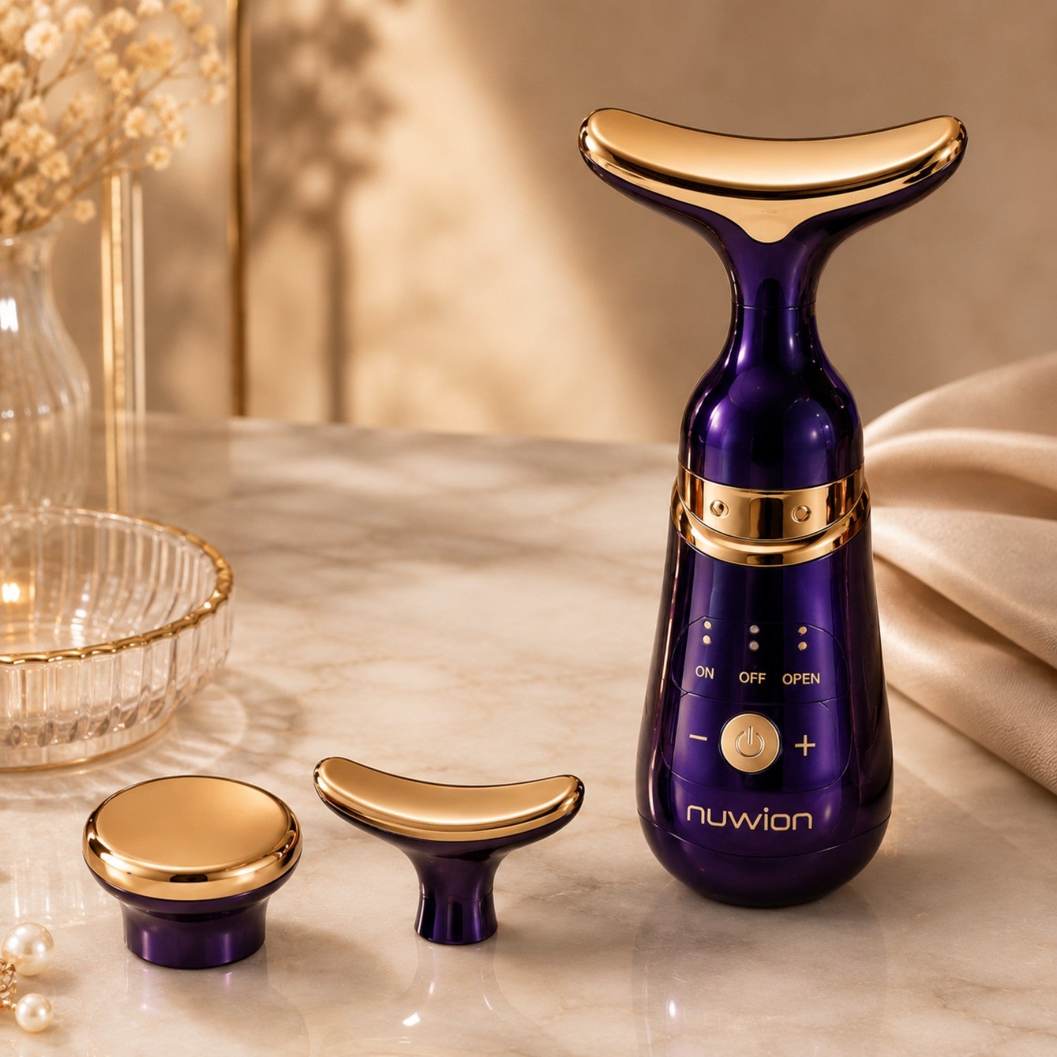 GlowLift Gesichtsmassagegerät in Lila und Gold mit zwei austauschbaren Aufsätzen